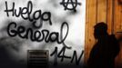 A man casts his shadow as he walks past a graffiti calling for a general strike in Madrid November 13, 2012. Spain's two largest labour unions have called for a general strike on November 14, the second against the conservative government since they took power in December and coinciding with industrial action in Portugal on the same day. REUTERS/Sergio Perez (SPAIN - Tags: BUSINESS EMPLOYMENT POLITICS CIVIL UNREST) Published: Lis. 13, 2012, 10:54 dop.