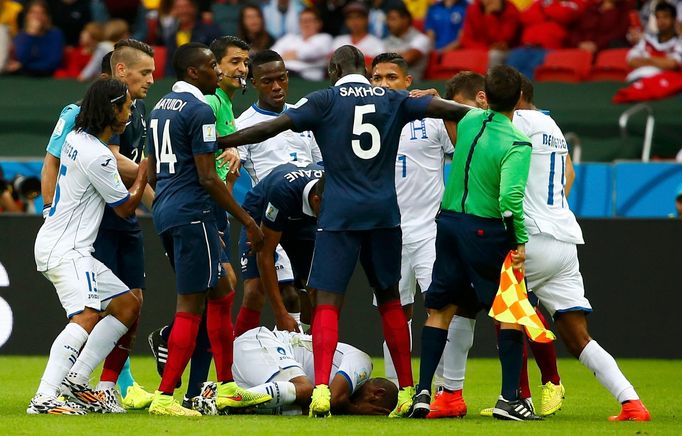 Wilson Palacios of Honduras lies on the pitch during a scuffle with the French players during their 2014 World Cup Group E soccer match at the Beira Rio stadium in Porto