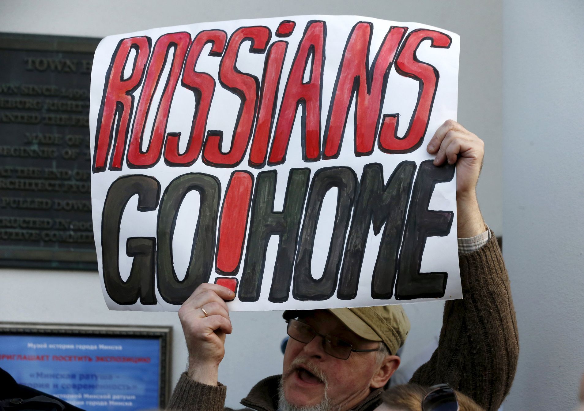 A man holds a placard during the opposition meeting against the deployment of Russian military bases in Minsk