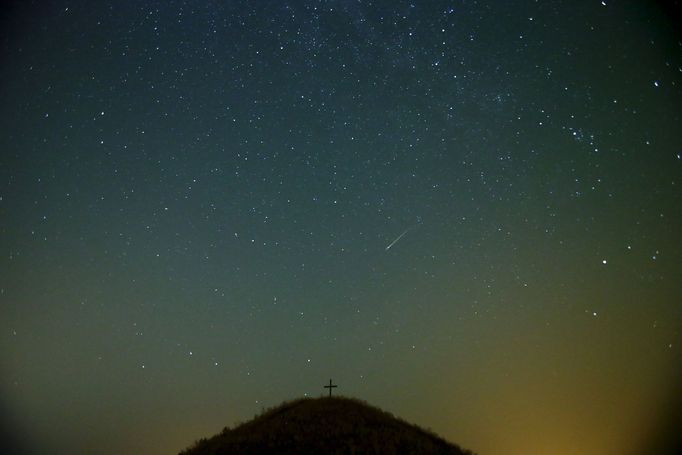 A meteor streaks across the sky over Leeberg hill during the Perseid meteor shower near Grossmugl