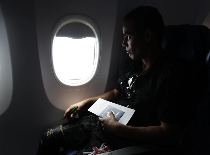 Luis Salgado, nicknamed Chucho, holds his passport as he takes his first flight ever from Havana to Miami, March 13, 2013. Chucho was granted a U.S. visa based on his father's status as legal resident in Texas, and he was reunited in Miami with his father, Jesus Salgado, who had escaped Cuba on a frail boat ten years earlier. The Salgados are among many Cubans taking advantage of Cuba's new travel policy in place since last January, which allows citizens to leave the country with just a passport and no need for much-hated exit visas required since 1961. Picture taken March 13, 2013. REUTERS/Desmond Boylan (CUBA - Tags: POLITICS SOCIETY) Published: Dub. 11, 2013, 1:15 odp.