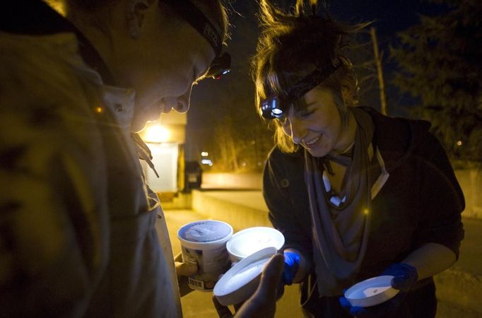 Anna-Rae Douglass (L), 23, and Robin Pickell, practicsing 'freegans' inspect cashew ice-cream in a dumpster behind an organic grocery store in Coquitlam, British Columbia April 5, 2012. A 'freegan' is someone who gathers edible food from the garbage bins of grocery stores or food stands that would otherwise have been thrown away. Freegans aim to spend little or no money purchasing food and other goods, not through financial need but to try to address issues of over-consumption and excess. Picture taken April 5, 2012. REUTERS/Ben Nelms (CANADA - Tags: SOCIETY) ATTENTION EDITORS PICTURE 20 OF 21 FOR PACKAGE 'DUMPSTER DIVING FOR FOOD' Published: Kvě. 15, 2012, poledne