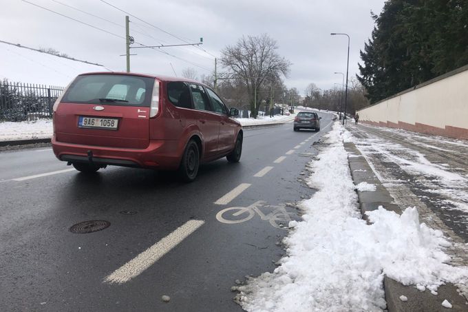 Cyklopruh v Praze v zimě, když napadá sníh. Shrnují ho na silnici... pro cyklisty problém.