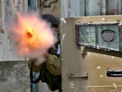 Izraelský voják střílí nábojnici se slzným plynem během střetů s Palestinci v uprchlickém táboře Balata ve městě Nabulus na Západním břehu. (Nabulus 21. února)