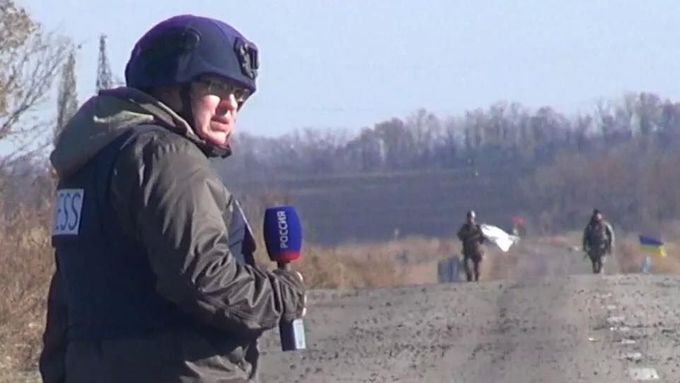 Alexandr Rogatkin při reportáži o ukrajinských vojácích (v pozadí s bílou vlajkou).