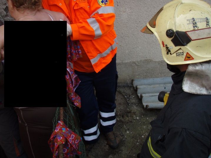 Hasiči vyprošťují ženu, která se po pádu ze schodů nabodla na plot