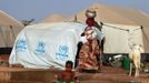 A woman walks past a child playing with water in a refugee camp in Sevare January 26, 2013. REUTERS/Eric Gaillard (MALI - Tags: CIVIL UNREST CONFLICT SOCIETY) Published: Led. 26, 2013, 6:44 odp.