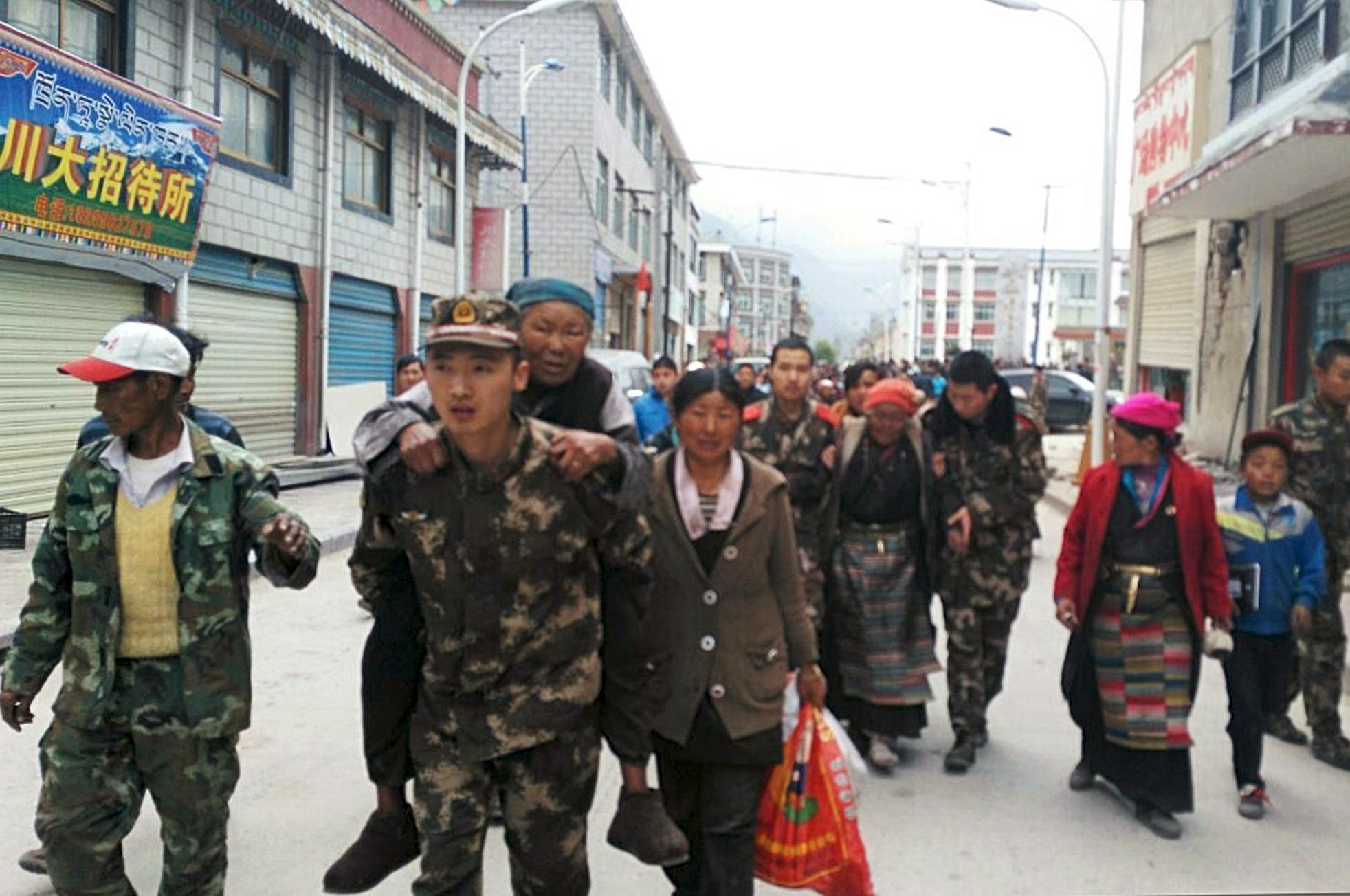 Rescuers help injured residents to get to safe area, after a 7.9 magnitude earthquake hit Nepal, in Xigaze Prefecture