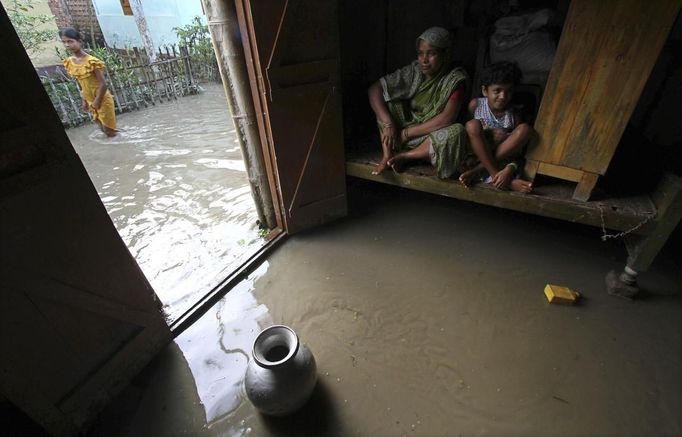 Flood-affected residents sit inside their flooded house at Dhuhibala village in the northeastern Indian state of Assam July 1, 2012. Incessant heavy rains in northeast India have caused massive flooding and landslides, killing more than 60 people, local media reported on Sunday. REUTERS/Utpal Baruah (INDIA - Tags: DISASTER ENVIRONMENT) Published: Čec. 1, 2012, 5:07 odp.