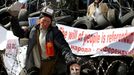 A pro-Russia protester breaks a piece of stone at a barricade outside a regional government building in Donetsk, in eastern Ukraine April 15, 2014.