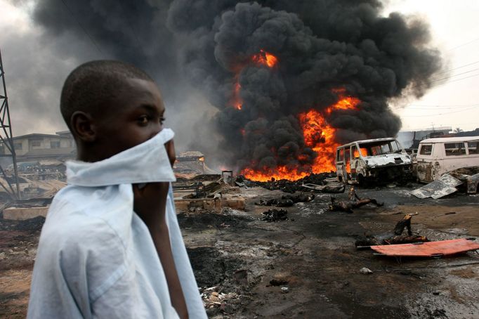 Chlapec na spáleništi poblíž nigerijského Lagosu si zakrývá tvář. V tomto místě se vzňal ropovod, o život přišlo podle agentury Reuters až 500 lidí. Dýchat se dalo jen s obtížemi.