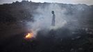 A man stands next to burning coal to make it for domestic use such as for cooking purposes at Dhanbad district in the eastern Indian state of Jharkhand September 19, 2012. With oil and gas output disappointing and hydropower at full throttle, Asia's third-largest economy still relies on coal for most of its vast energy needs. About 75 percent of India's coal demand is met by domestic production and, according to government plans, that won't change over the next five years. Picture taken September 19, 2012. To match INDIA-COAL/ REUTERS/Ahmad Masood (INDIA - Tags: BUSINESS EMPLOYMENT ENERGY SOCIETY ENVIRONMENT) Published: Říj. 21, 2012, 10:01 odp.