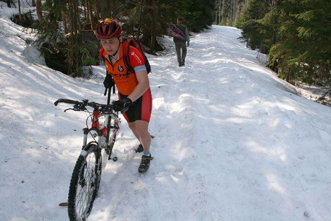 Nedočkavý cyklista se brodí sněhem k Plešnému jezeru