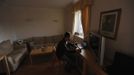 George Kapetanios looks at a laptop computer at his flat in Potters Bar, on the outskirts of London