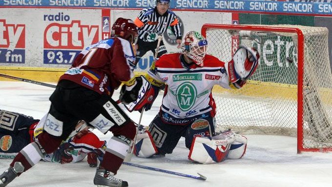Sparťan Tomáš Netík (vlevo) sleduje ránu Jiřího Vykoukala, která šla těsně vedle branky pardubického Jána Lašáka.