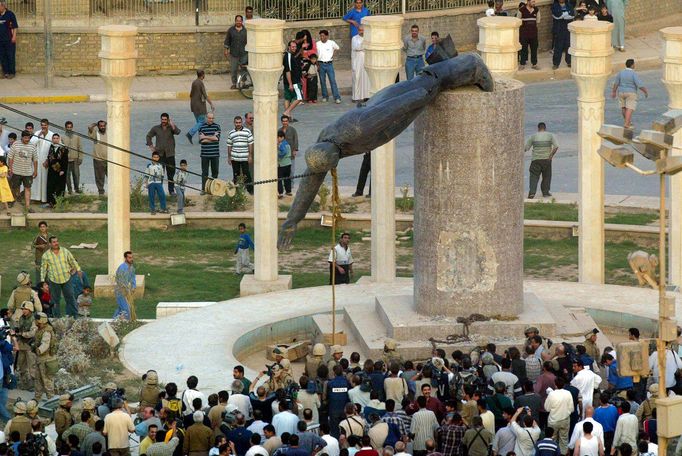 Iráčané sledují pád sochy iráckého prezidenta Saddáma Husajna na  bagdádském náměstí al-Fardous 9. dubna 2003.