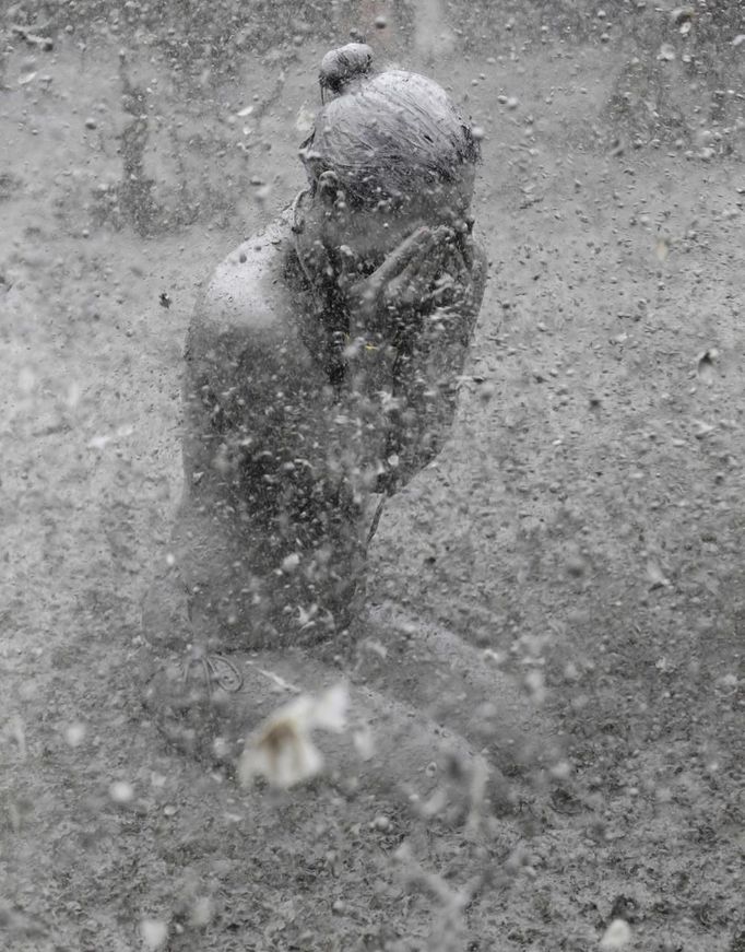 A woman plays in the mud during the Boryeong Mud Festival at Daecheon beach in Boryeong, about 190 km (118 miles) southwest of Seoul, July 15, 2012. About 2 to 3 million domestic and international tourists visit the beach during the annual mud festival, according to the festival organisers. REUTERS/Lee Jae-Won (SOUTH KOREA - Tags: SOCIETY TRAVEL) Published: Čec. 15, 2012, 6:51 dop.