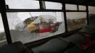 The Olympic stadium for the Sochi 2014 Winter Olympics is seen through the broken window of a scraped bus within the perimeter of the Olympic Park in Adler, near Sochi February 18, 2013. Although many complexes and venues in the Black Sea resort of Sochi mostly resemble building sites that are still under construction, there is nothing to suggest any concern over readiness. Construction will be completed by August 2013 according to organizers. The Sochi 2014 Winter Olympics opens on February 7, 2014. REUTERS/Kai Pfaffenbach (RUSSIA - Tags: BUSINESS CONSTRUCTION ENVIRONMENT SPORT OLYMPICS) Published: Úno. 18, 2013, 5:58 odp.