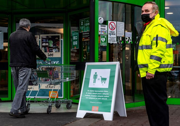 Pracovník ostrahy hlídá před vstupem do hypermarketu v Ústí nad Labem.