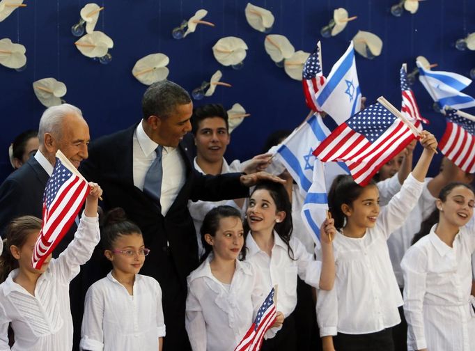 U.S. President Barack Obama and Israel's President Shimon Peres (L) pose for a photo with Israeli children during a welcoming ceremony at Peres' residence in Jerusalem March 20, 2013. Making his first official visit to Israel, Obama pledged on Wednesday unwavering commitment to the security of the Jewish State where concern over a nuclear-armed Iran has clouded U.S.-Israeli relations. REUTERS/Ronen Zvulun (JERUSALEM - Tags: POLITICS TPX IMAGES OF THE DAY) Published: Bře. 20, 2013, 7:34 odp.