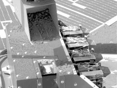 Robotické rameno sondy Phoenix nabírá vzorky půdy z Marsu pro analýzu.
