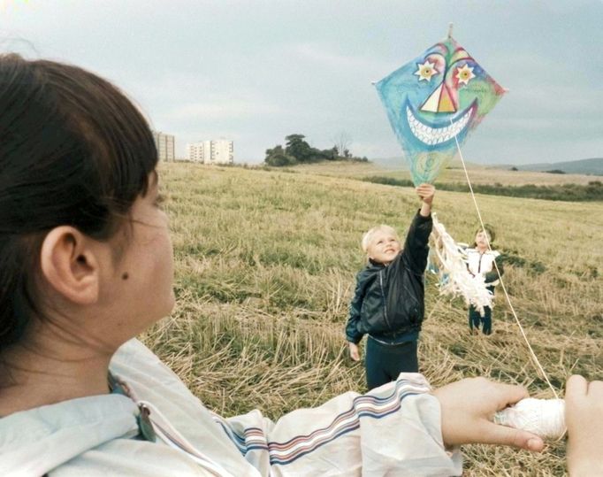 Děti pouští draka na podzimním poli v Československu, 5. října 1987. Kolorováno