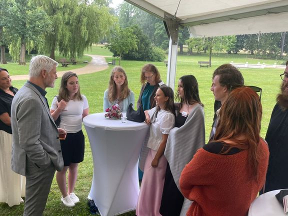 Prezident Petr Pavel při rozhovoru s dívkami, které pomáhají druhým lidem. Mají na sobě deku, protože se kvůli počasí ochladilo.