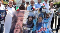 Demonstrators hold a poster during a protest in solidarity with journalists in Gaza, in Sidon