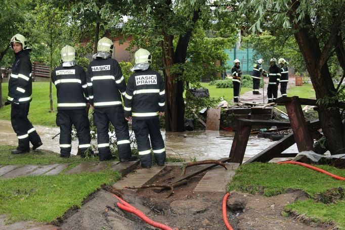 Hasiči přijeli zkontrolovat můstek, který povodeň zničila. Hrozí, že se utrhne.