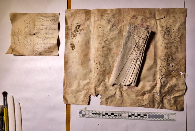 Listinné nálezy položené na relikviáři Jindřicha Libraria po vyjmutí ze zazděné niky.