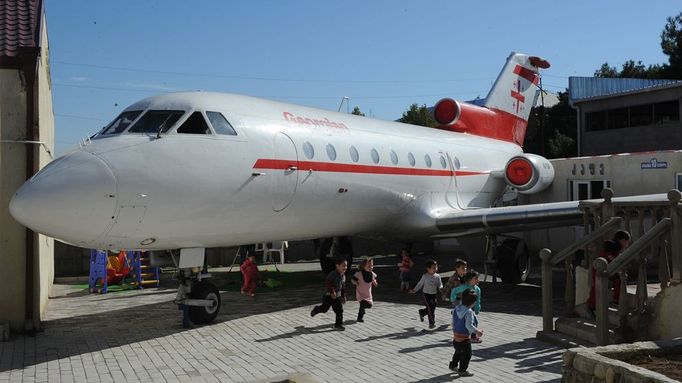 A picture taken on October 29, 2012, shows children playing near a Soviet-era Yakovlev Yak-42 plane turned into their kindergarten in the Georgian city of Rustavi, some 25 km southeast of the capital Tbilisi. Local head teacher Gari Chapidze bought the old but fully functional Yak-42 from Georgian Airways and refurbished its interior with educational equipment, games and toys but left the cockpit instruments intact so they could be used as play tools.