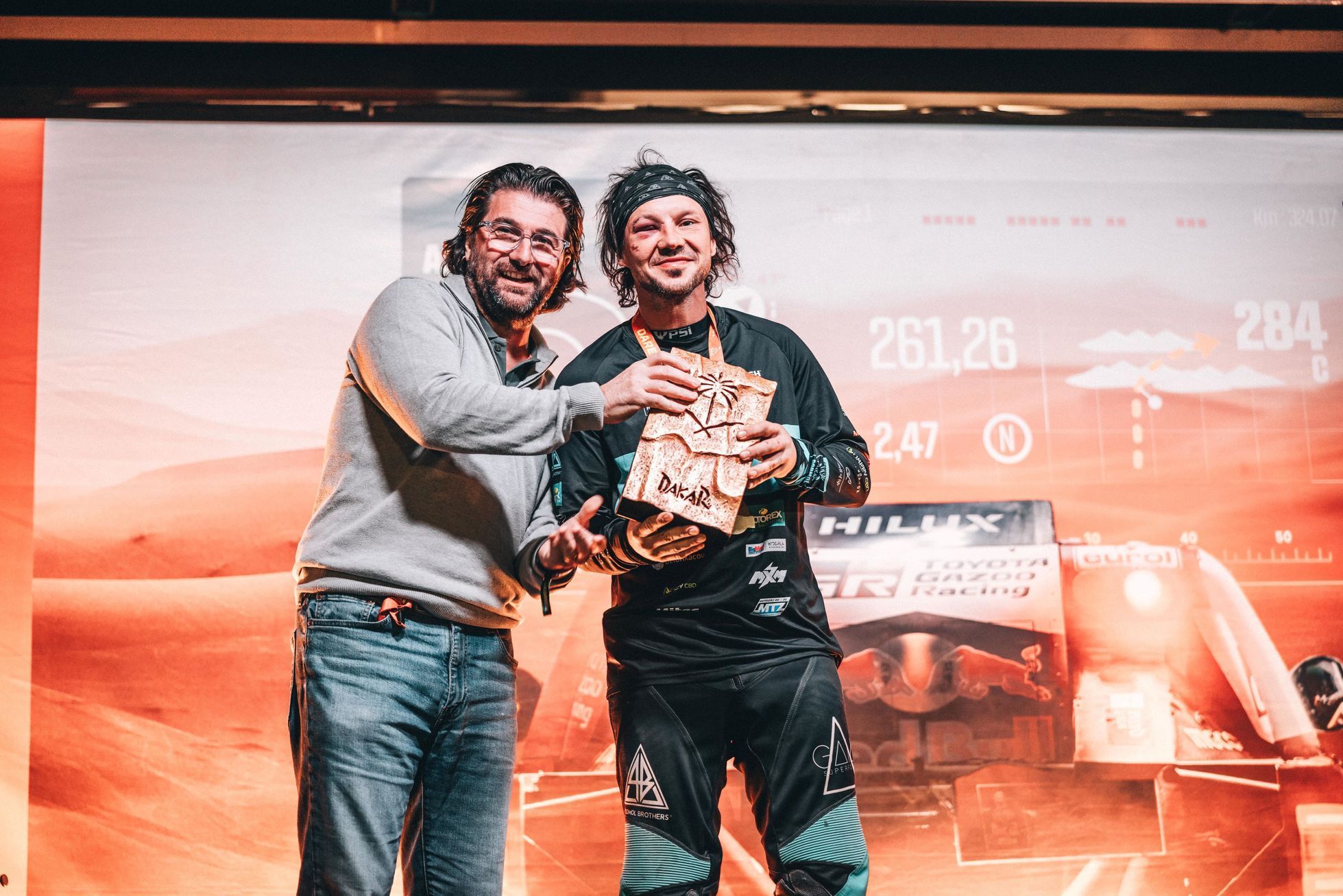 Libor Podmol přebírá cenu za odvahu od ředitele Rallye Dakar Davida Castery