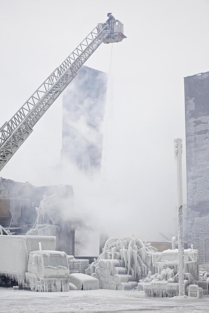 Firefighters spray hotspots on an ice-covered warehouse that caught fire Tuesday night in Chicago January 23, 2013. Fire department officials said it is the biggest fire the department has had to battle in years and one-third of all Chicago firefighters were on the scene at one point or another trying to put out the flames. An Arctic blast continues to grip the U.S. Midwest and Northeast Wednesday, with at least three deaths linked to the frigid weather, and fierce winds made some locations feel as cold as 50 degrees below zero Fahrenheit. (minus 46 degrees Celsius). REUTERS/John Gress (UNITED STATES - Tags: DISASTER ENVIRONMENT) Published: Led. 23, 2013, 5:50 odp.