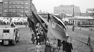 Snímek z roku 1952 zachycuje jeden z průvodů žen "ze všech částí hlavního města, které směřovaly k Průmyslovému paláci na Starém výstavišti v Praze, kde ústřední akční výbor Národní fronty pořádal manifestaci u příležitosti Mezinárodního dne žen".
