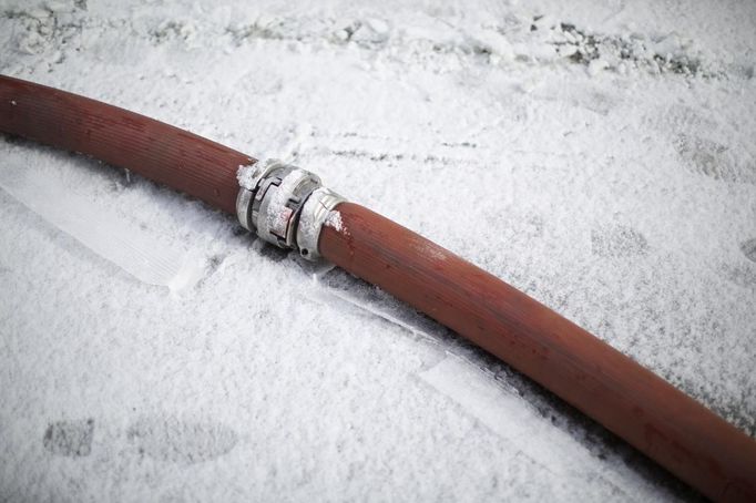 A firehose lies in the snow following a warehouse fire, which is still burning and started on Tuesday in Chicago January 24, 2013. Fire department officials said it is the biggest fire the department has had to battle in years and one-third of all Chicago firefighters were on the scene at one point or another trying to put out the flames. REUTERS/John Gress (UNITED STATES - Tags: DISASTER ENVIRONMENT) Published: Led. 24, 2013, 10:32 odp.