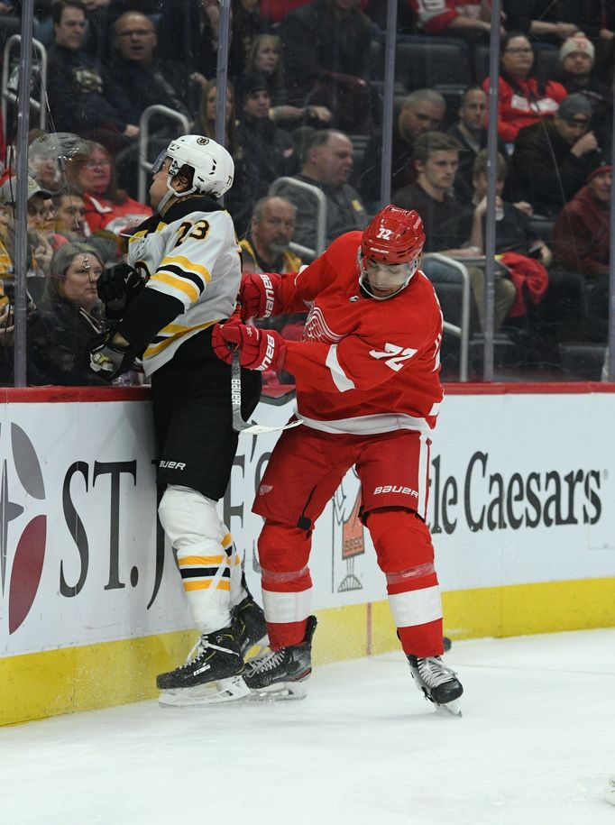 Feb 9, 2020; Detroit, Michigan, USA; Detroit Red Wings left wing Andreas Athanasiou (72) checks Boston Bruins defenseman Charlie McAvoy (73) during the second period at L