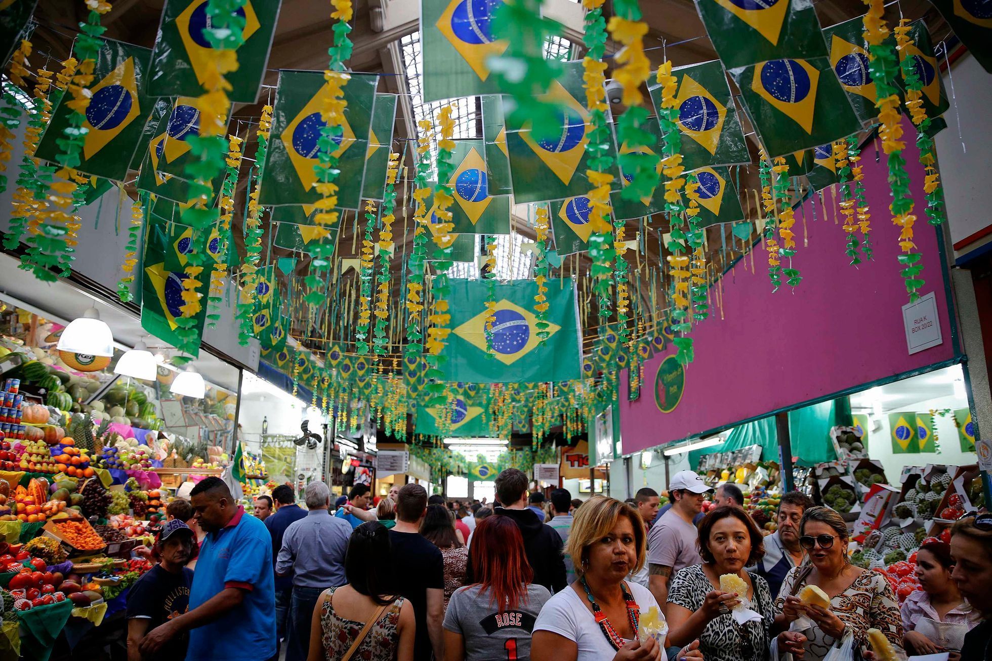 People eat snacks under Brazilian flags at a market decorated for the upcoming World Cup in Sao Paulo