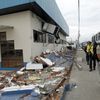 Police officers walk next to debris after an earthquake struck off Ecuador's Pacific coast, at Tarqui neighborhood in Manta
