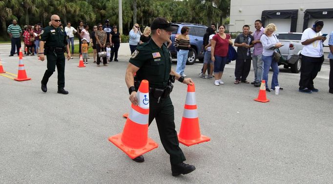 A Palm Beach County Sheriff's deputy sets up pylons to control lines and traffic as voters stand in a long line at the Supervisor of Elections office in West Palm Beach, Florida November 5, 2012. Palm Beach County Supervisor of Elections Supervisor Susan Bucher is one of five supervisors in heavily populated counties who has allowed in-person absentee voting after Florida Republican Governor Rick Scott refused to extend early voting. REUTERS/Joe Skipper (UNITED STATES - Tags: POLITICS ELECTIONS USA PRESIDENTIAL ELECTION) Published: Lis. 5, 2012, 6:29 odp.