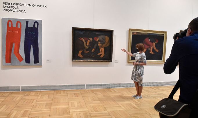 Mluvčí galerie ukazuje zleva obrazy Dvoje montérky od Filipa Nádvorníka z roku 2019 a Haldy - Opučárky a Žena na haldě od Valentina Držkovice (1929).