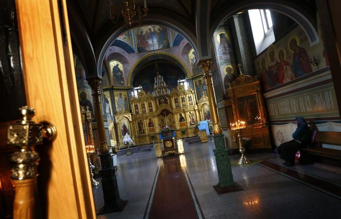 A woman sits in prayers inside the church of archangel Michael in Sochi, the host city for the Sochi 2014 Winter Olympics, February 18, 2013. REUTERS/Kai Pfaffenbach (RUSSIA - Tags: RELIGION SPORT OLYMPICS SOCIETY) Published: Úno. 18, 2013, 7:15 odp.