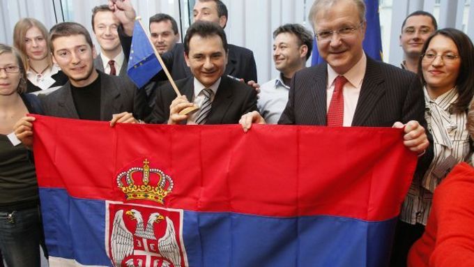Srbský vicepremiér Božidar Djelić a evropský komisař pro rozšíření Olli Rehn pózují v Bruselu se srbskou vlajkou.