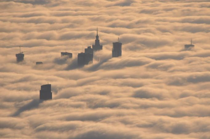 The tops of high rise buildings stick out from a blanket of think fog covering Warsaw early morning October 12, 2012. Picture taken October 12, 2012. REUTERS/Mateusz Olszowy (POLAND - Tags: CITYSPACE ENVIRONMENT) Published: Lis. 21, 2012, 3:54 odp.