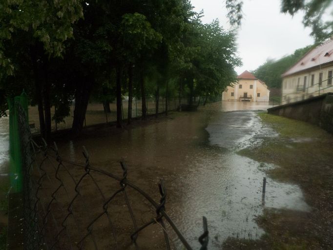 Postupující voda u přilehlého stavení.