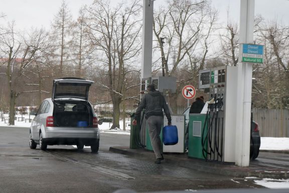 Motoristé si čepují palivo do zásoby do kanystrů.