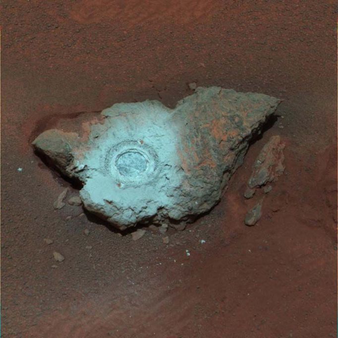 Bringing Out the Color in 'Bounce' 4/14/04 This false-color composite of the rock dubbed "Bounce" shows the rock after the Mars Exploration Rover Opportunity drilled into it with its rock abrasion tool. The drilling of the 7-millimeter-deep (0.3-inch) hole generated a bright powder. The color in this image has been enhanced to show that these tailings are relatively blue when compared with the unaltered rock (to the human eye, the tailings would appear red). This image was assembled from the infrared (750-nanometer), green (530-nanometer) and violet (430-nanometer) filters of the rover's panoramic camera. It was taken on sol 68. Image Credit: NASA/JPL/Cornell