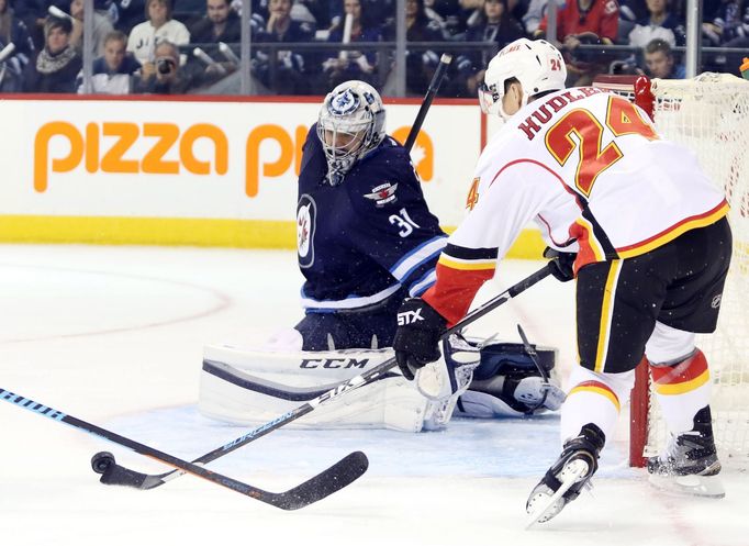 Ondřej Pavelec zasahuje proti střele Jiřího Hudlera.