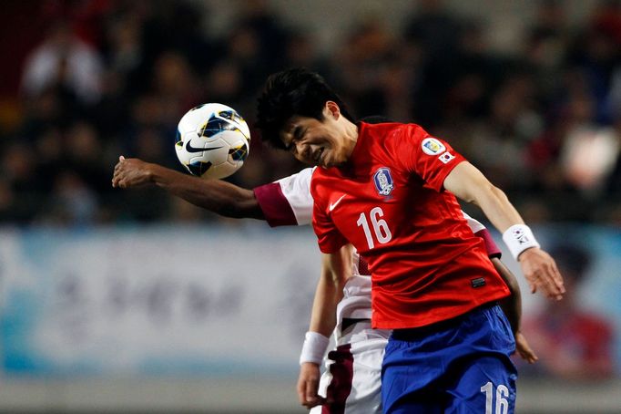 Korea - Katar (kvalifikace MS 2014) -  Ki Sung-Yueng a Khalfan Ibrahim bojují o míč.