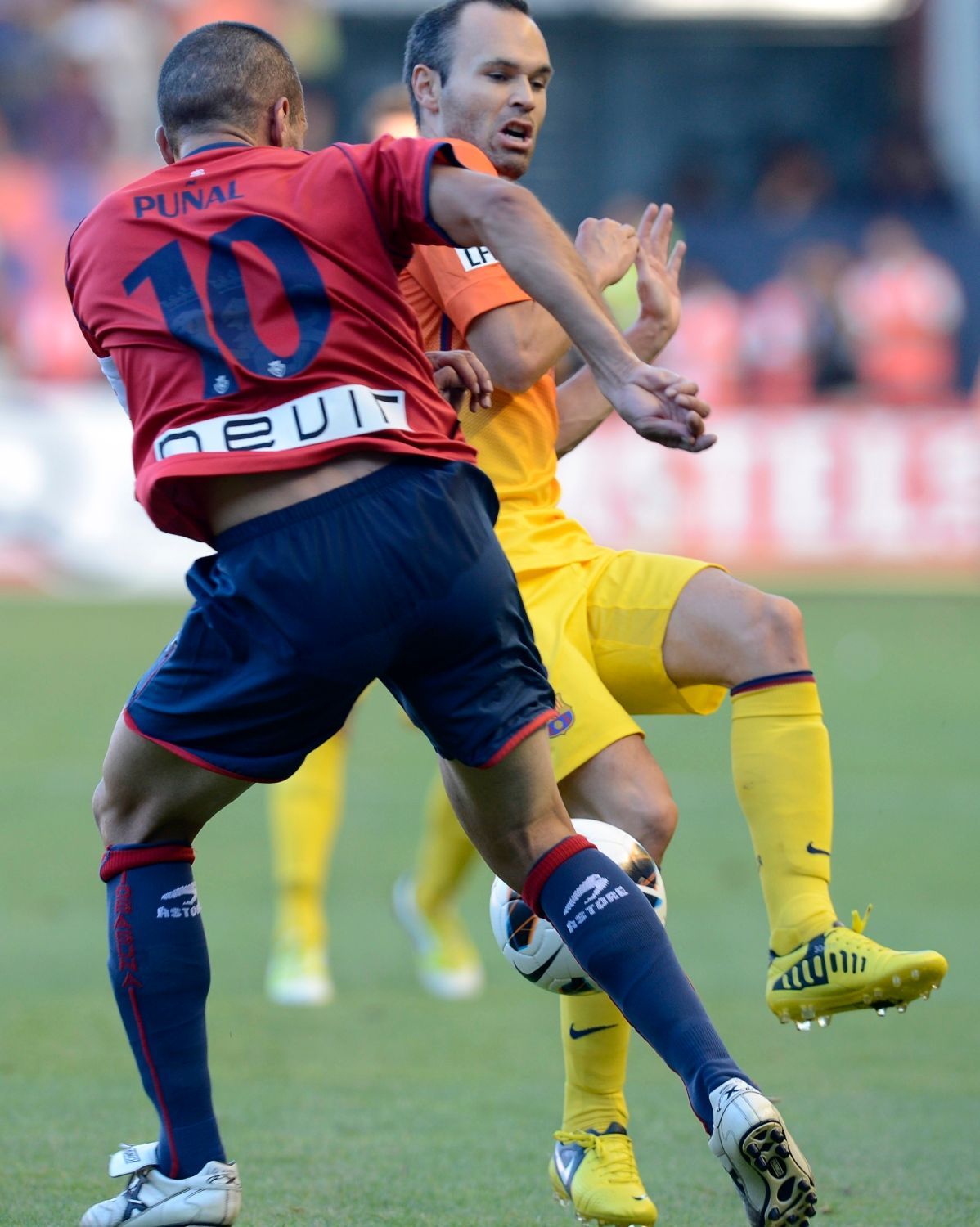 Fotbalista Barcelony Andrés Iniesta bojuje o míč s Franciscem Punaiem v utkání La Ligy 2012/13 s Osasunou.