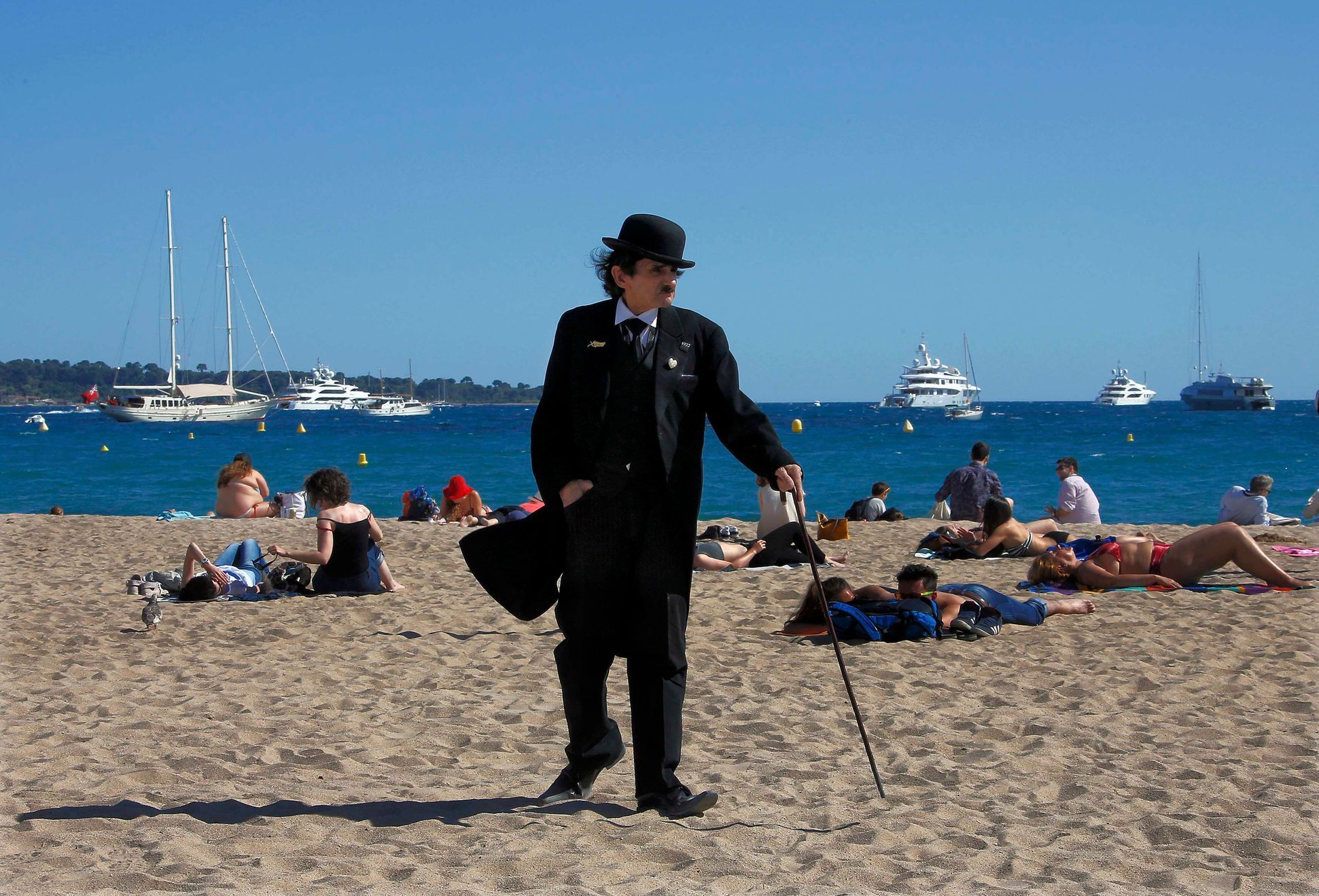 A man dressed as Charlie Chaplin walks on the beach during the 67th Cannes Film Festival in Cannes